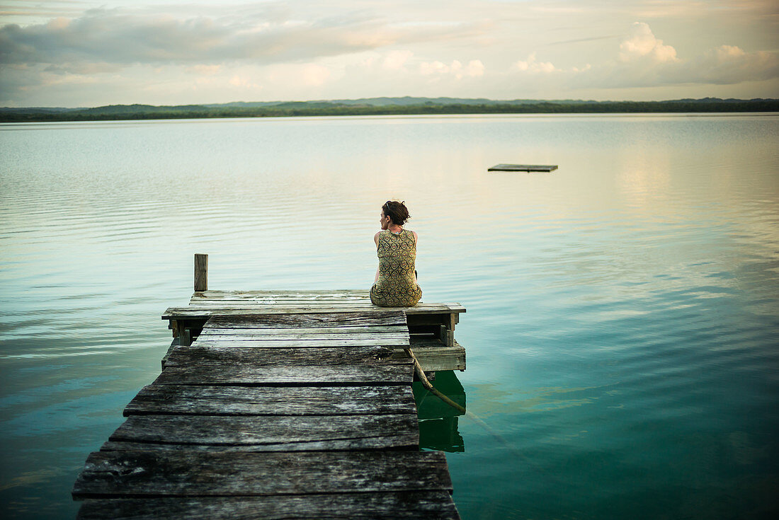 Woman sitting on the edge of a lake