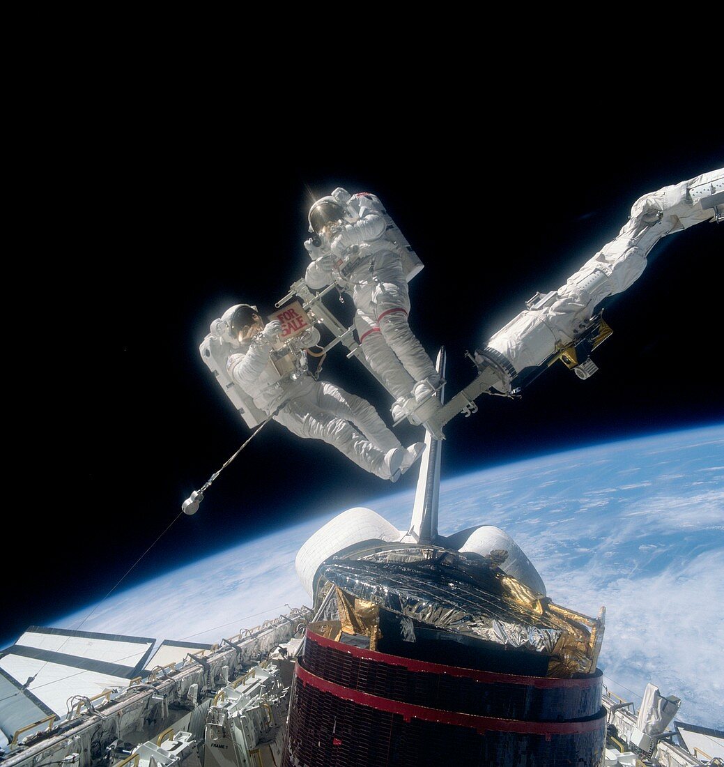 Astronauts recovering satellites