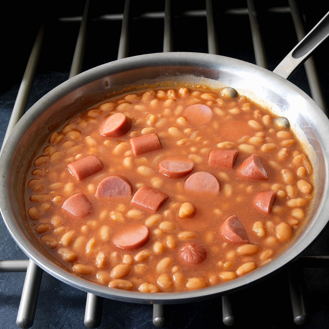 Frankfurters with baked beans in skillet