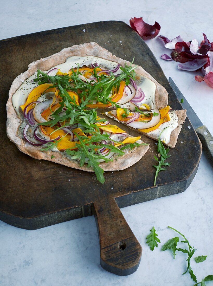 Vegetarian tarte flambée with coconut and Hokkaido pumpkin carpaccio and rocket