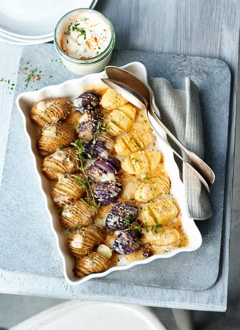 Three baked potatoes varieties with a garlic dip