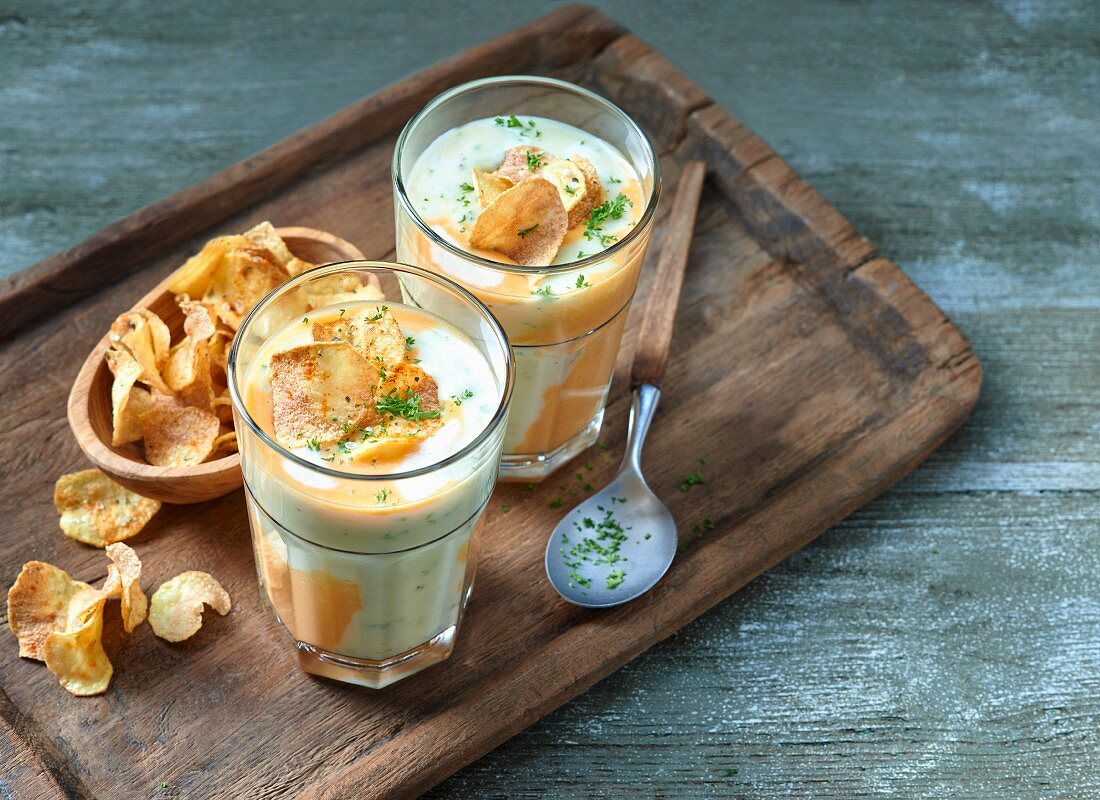 Potato soup with potato crisps and chopped herbs