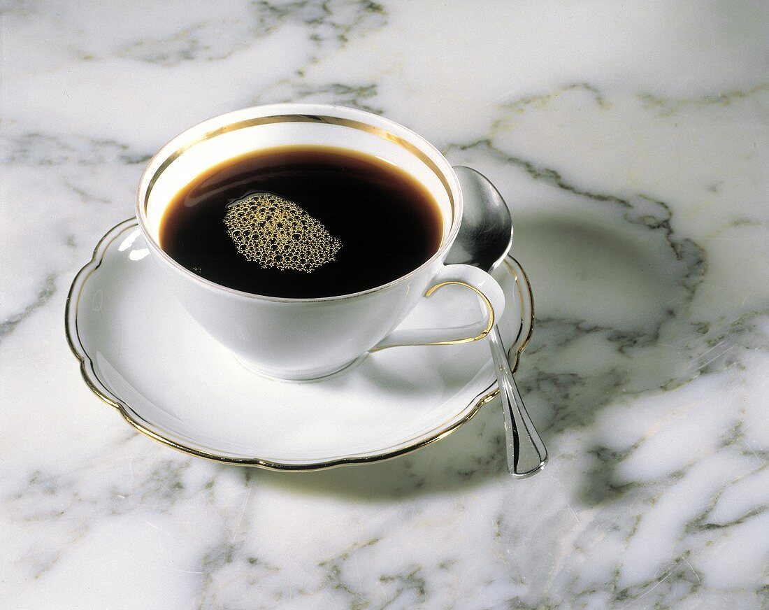 Eine Tasse schwarzer Kaffee (weiße Tasse mit Goldrand)