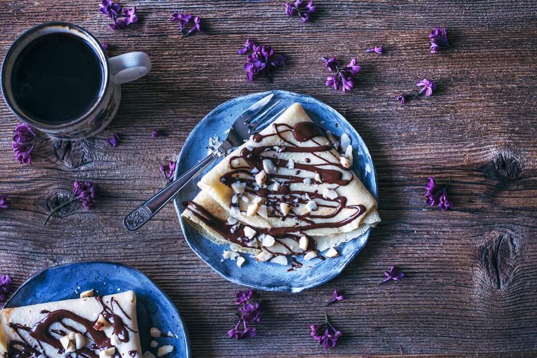 Crepes with dark chocolate drizzle and Brazil nuts
