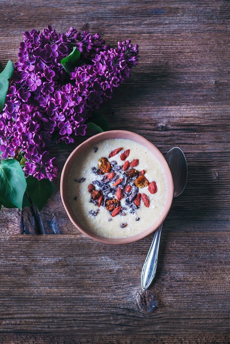 Bananen-Smoothie-Bowl mit Kokos, Kakaonibs, Goji- und Inkabeeren (Aufsicht)