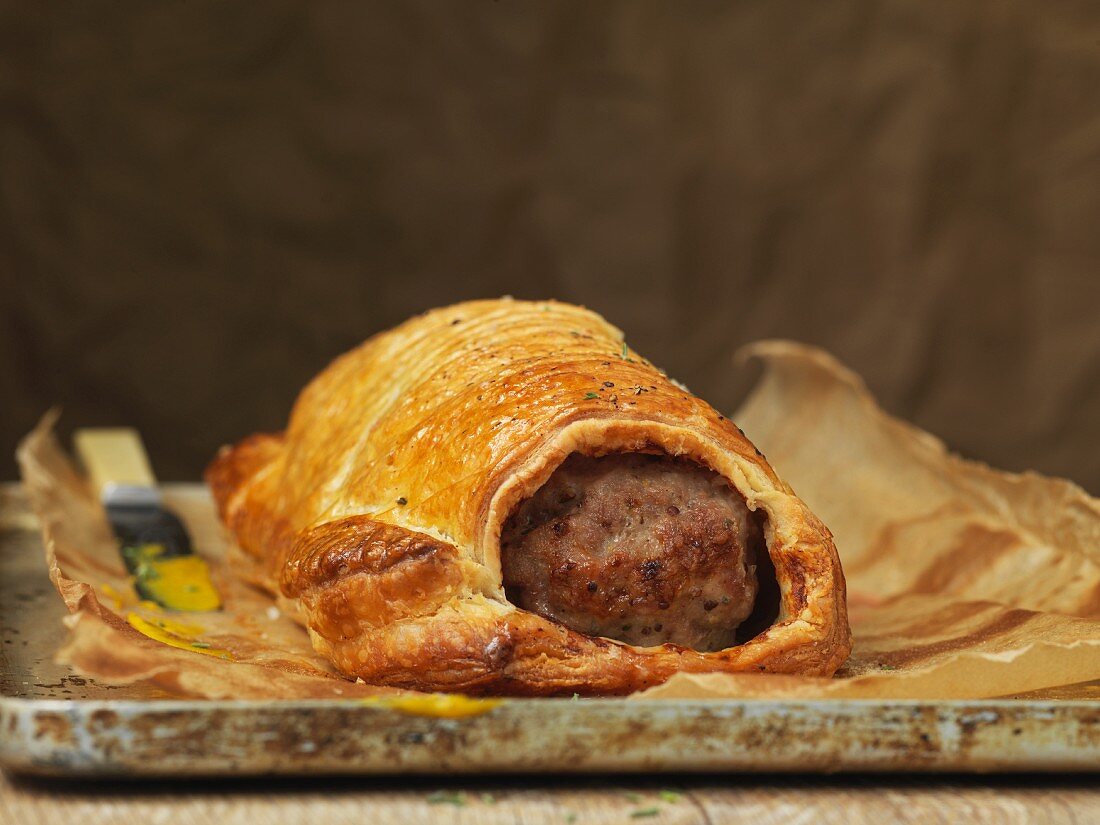 Hausgemachte Wurstpastete mit Blätterteig auf Backblech