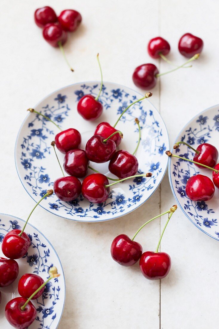 Fresh cherries on and around blue and white plates