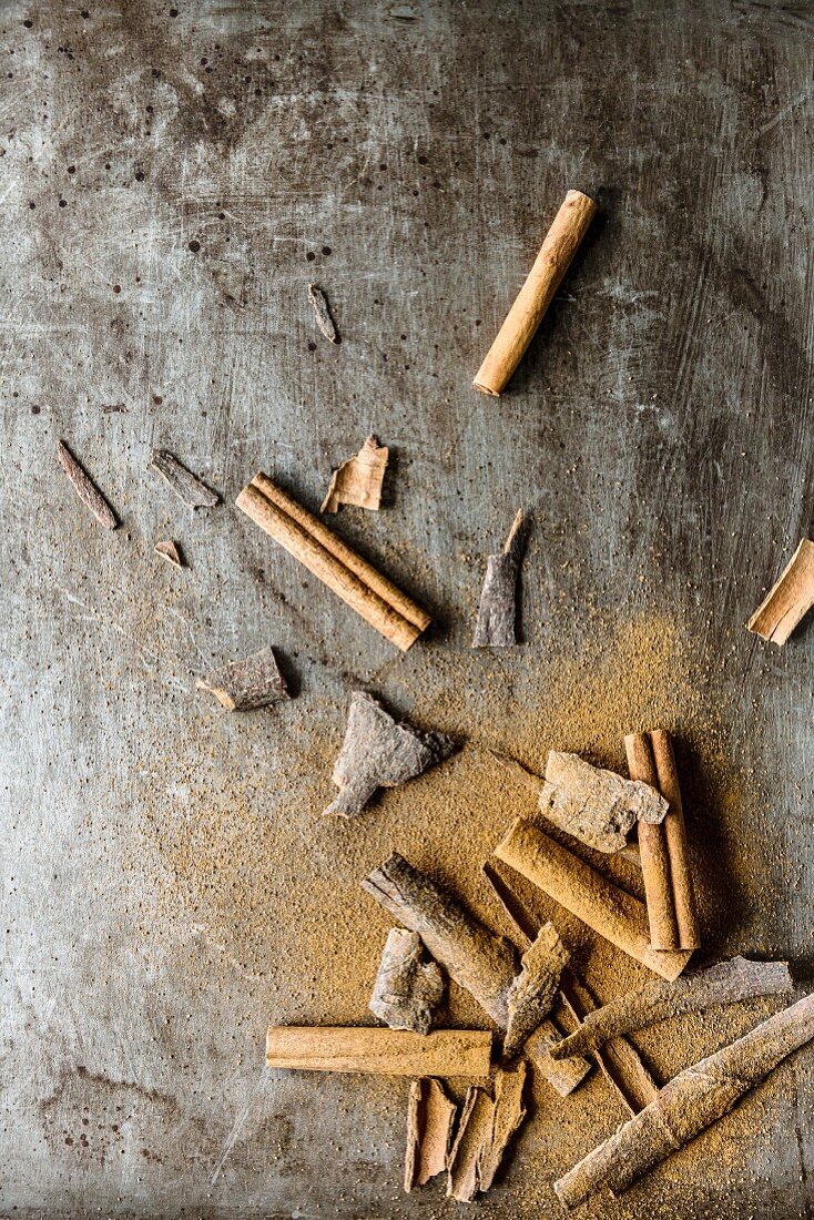 Cinnamon sticks, cassia bark and cinnamon powder on a metal tray