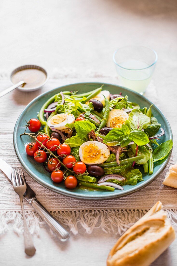 Nizza-Salat mit Bohnen. Eiern, Anchovis, Oliven und Rispentomaten