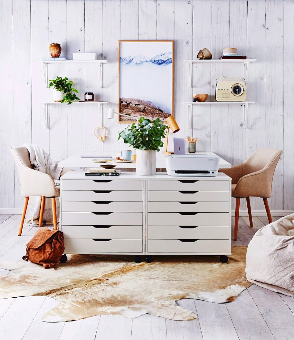 Home office with two white drawer containers, desks and wall brackets on a wooden wall