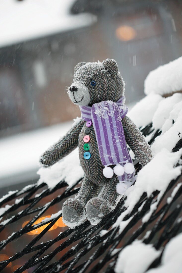 Tweed teddy bears wearing scarf sitting on snowy hammock
