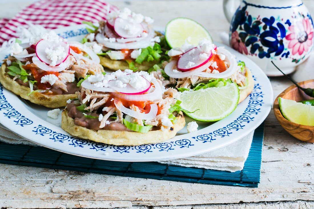 Sopes (cornmeal flatbreads, Mexico) with meat, beans and lettuce