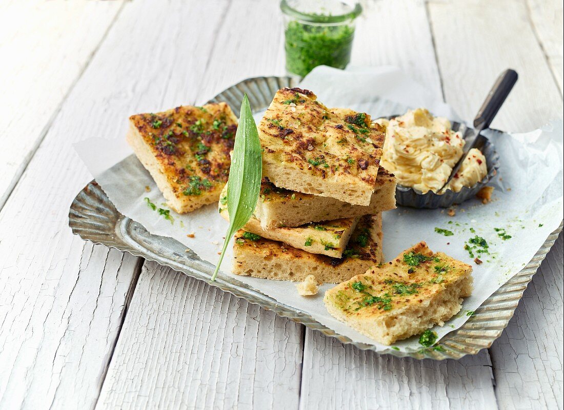 Foccacia on a tray with salted butter and bear's garlic pesto