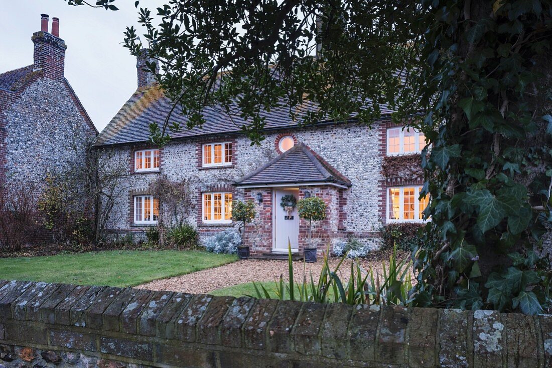 Typical English cobblestone house with front garden and garden wall