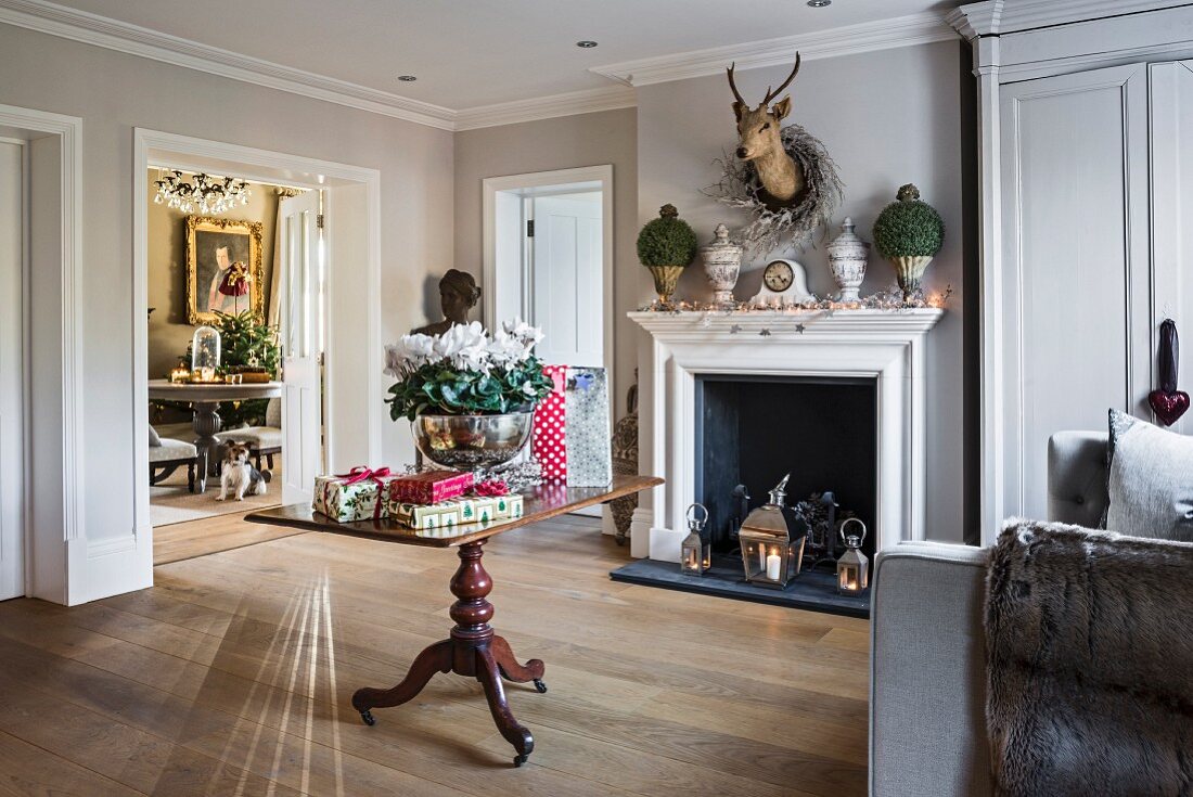 Christmas presents on table in front of decorated mantelpiece