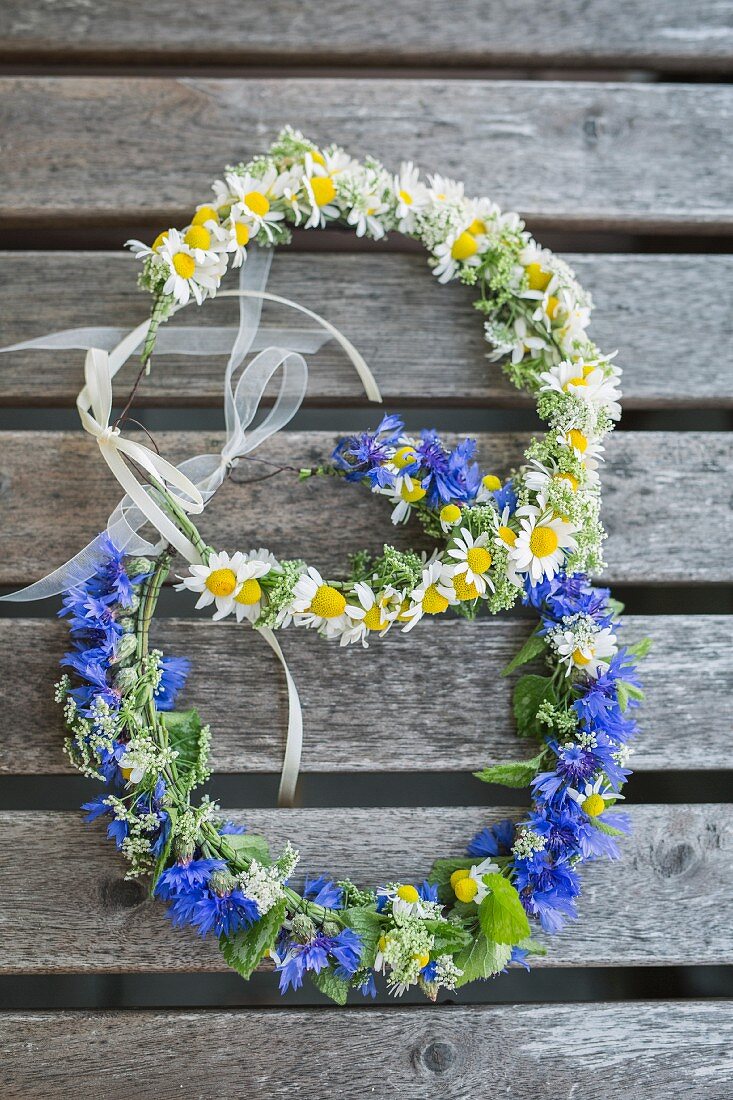 Two floral wreaths on wooden surface