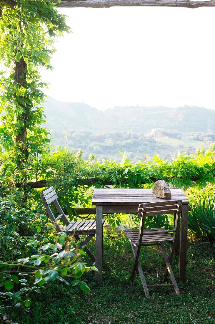 Seating area on terrace with climber-covered pergola and panoramic view