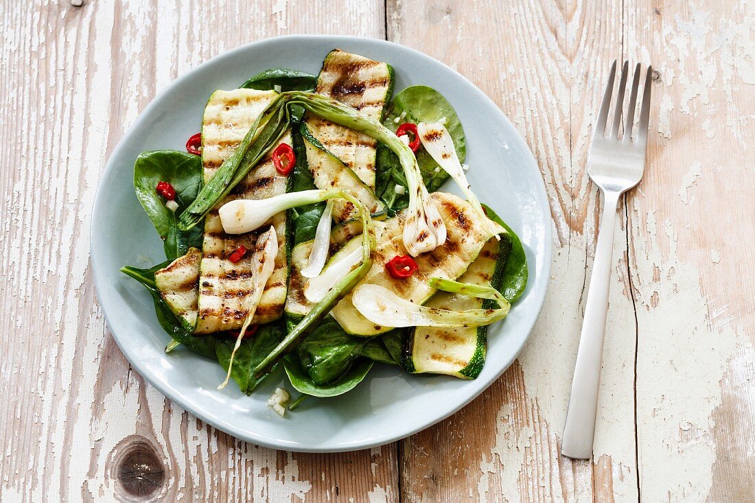 Salad with spinach, grilled zucchini, spring onion on plate, vegan