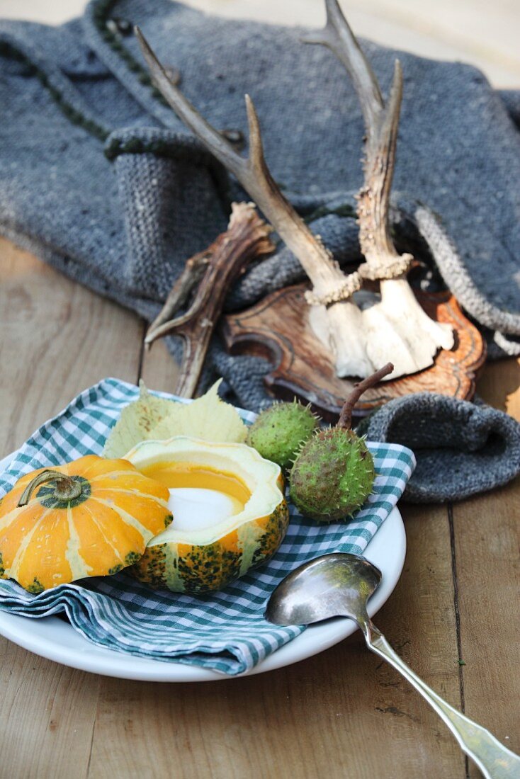 Pumpkin soup with cream served in a mini pumpkin