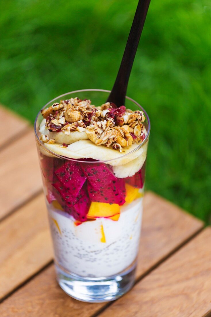 Glass of chia pudding with different fruits and cereals