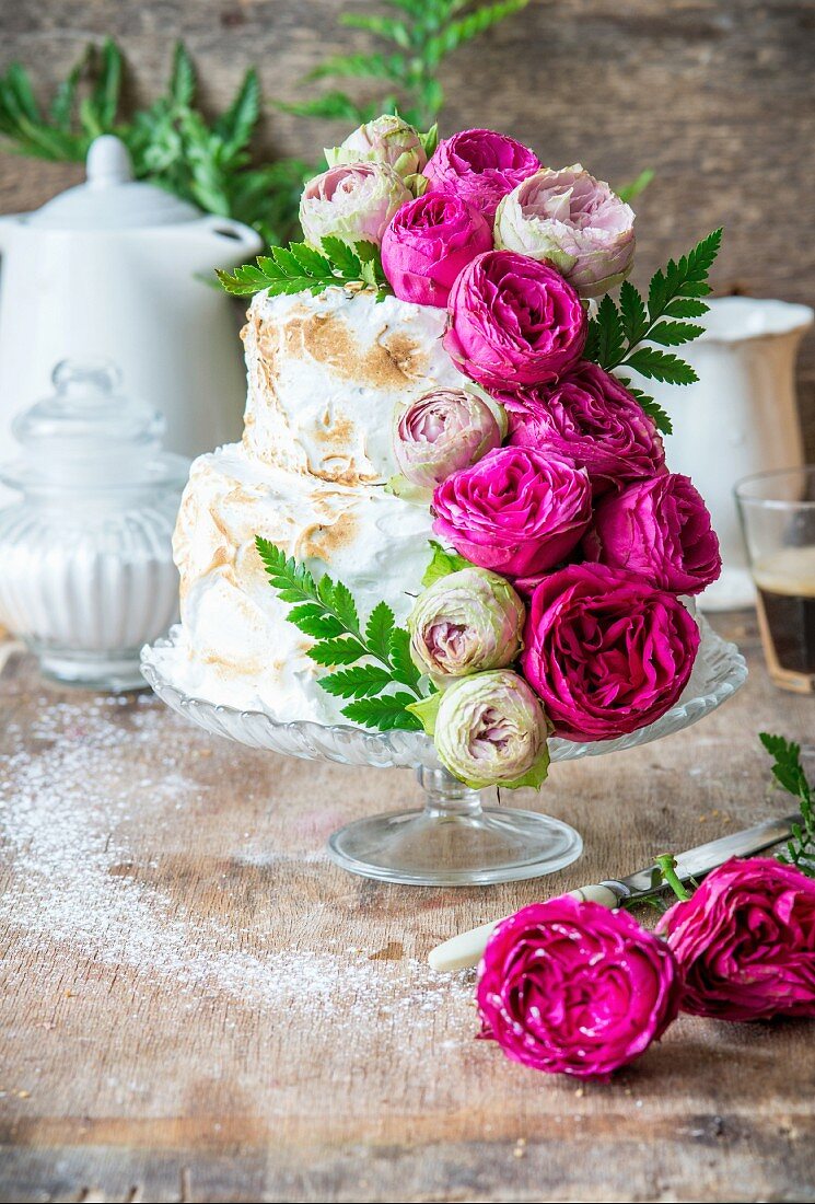 Rosenwasser-Schichtkuchen mit Baiser und pinken Rosen