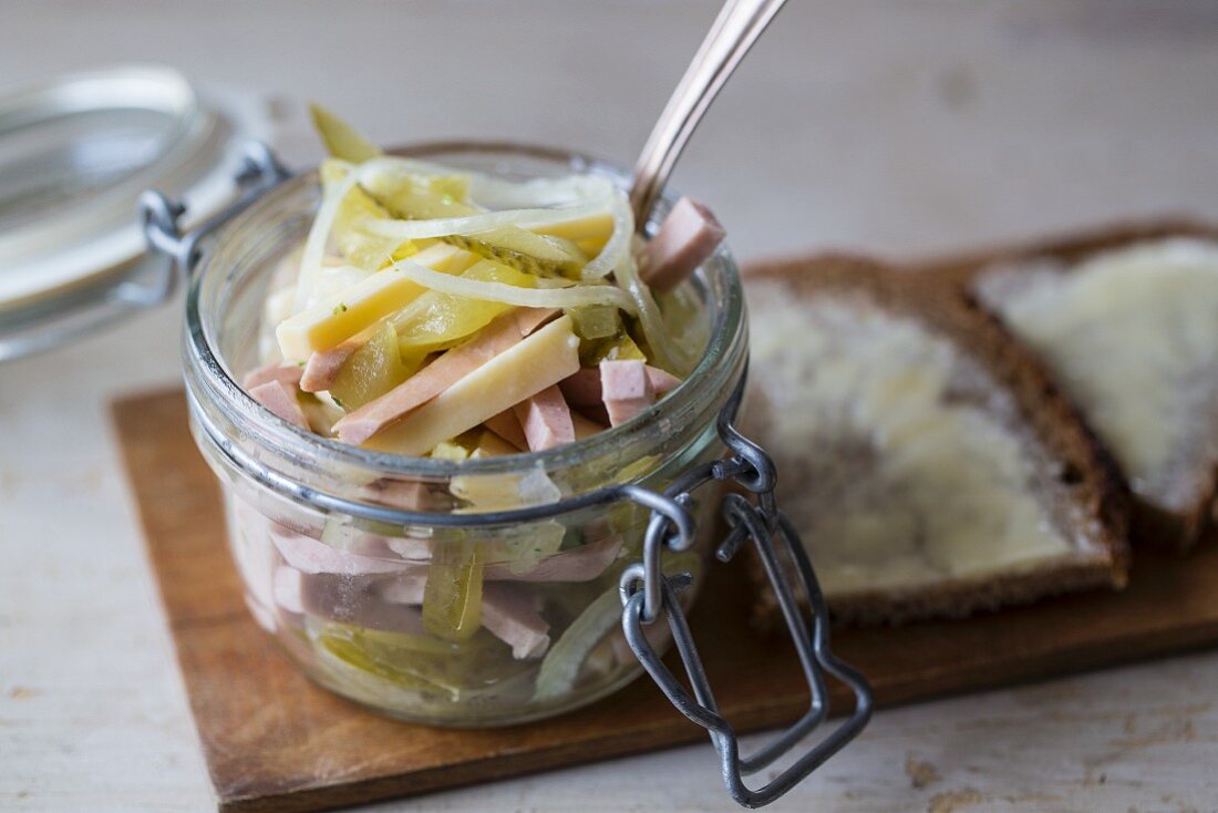 Swiss sausage salad in a glass jar with buttered bread