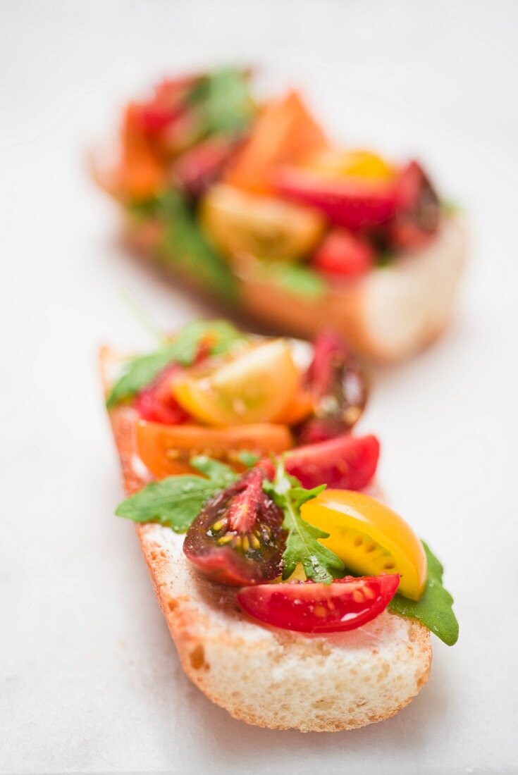 Baguette with cream cheese, various tomatoes and rocket