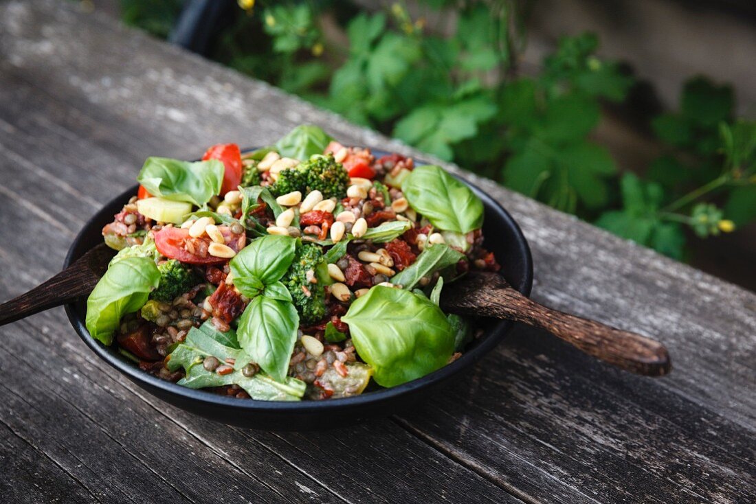 Reissalat mit rotem Reis, grünen Linsen, Tomaten, Brokkoli, Rucola, Bailikum und gerösteten Pinienkernen