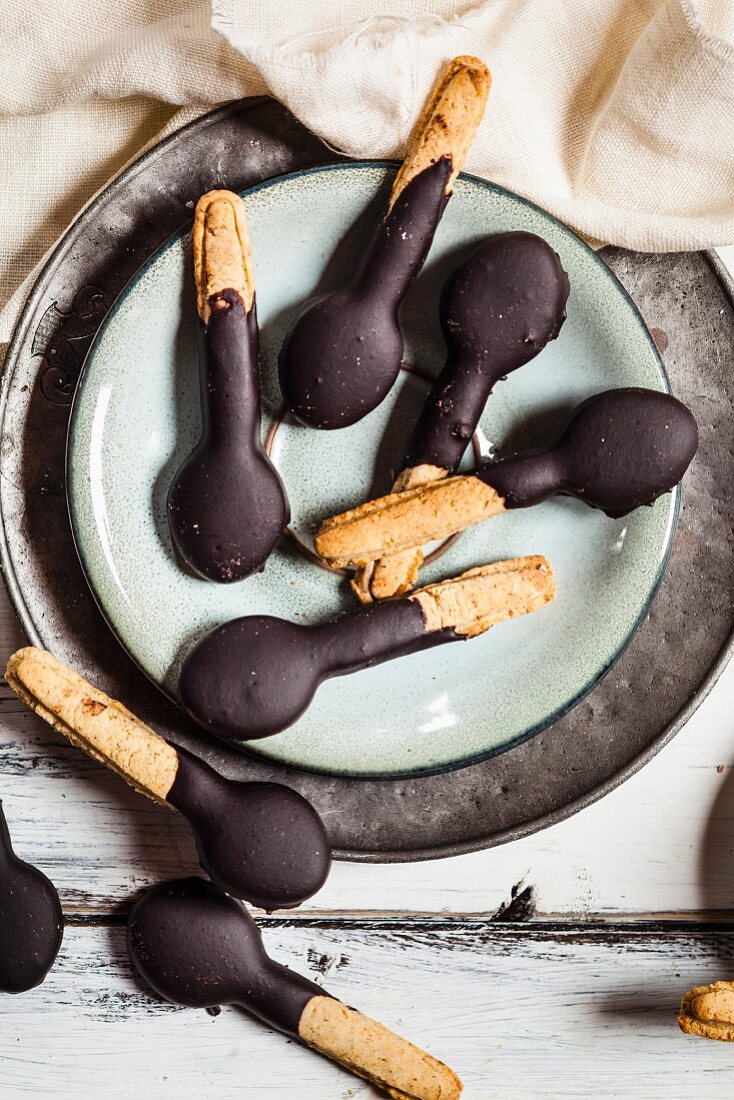 Spoon-shaped biscuits with chocolate icing on plate