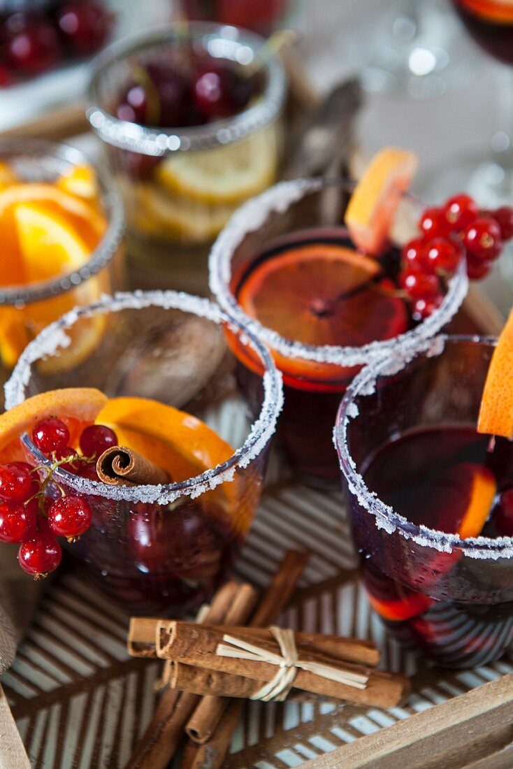 Sangria with cinnamon, orange, berries in a glass with sugar