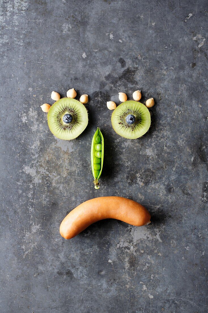 A photo to symbolise hidden carbohydrates - a sad smiley made up of fruit, vegetables and a sausage