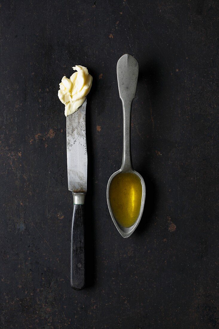 Butter on a knife and a spoonful of oil