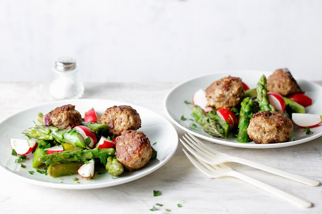 Fried meatballs with green asparagus and radish salad