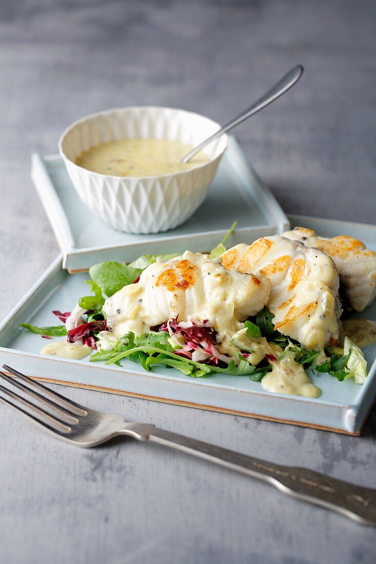 Fried monkfish on a bed of lettuce with orange and pepper sauce
