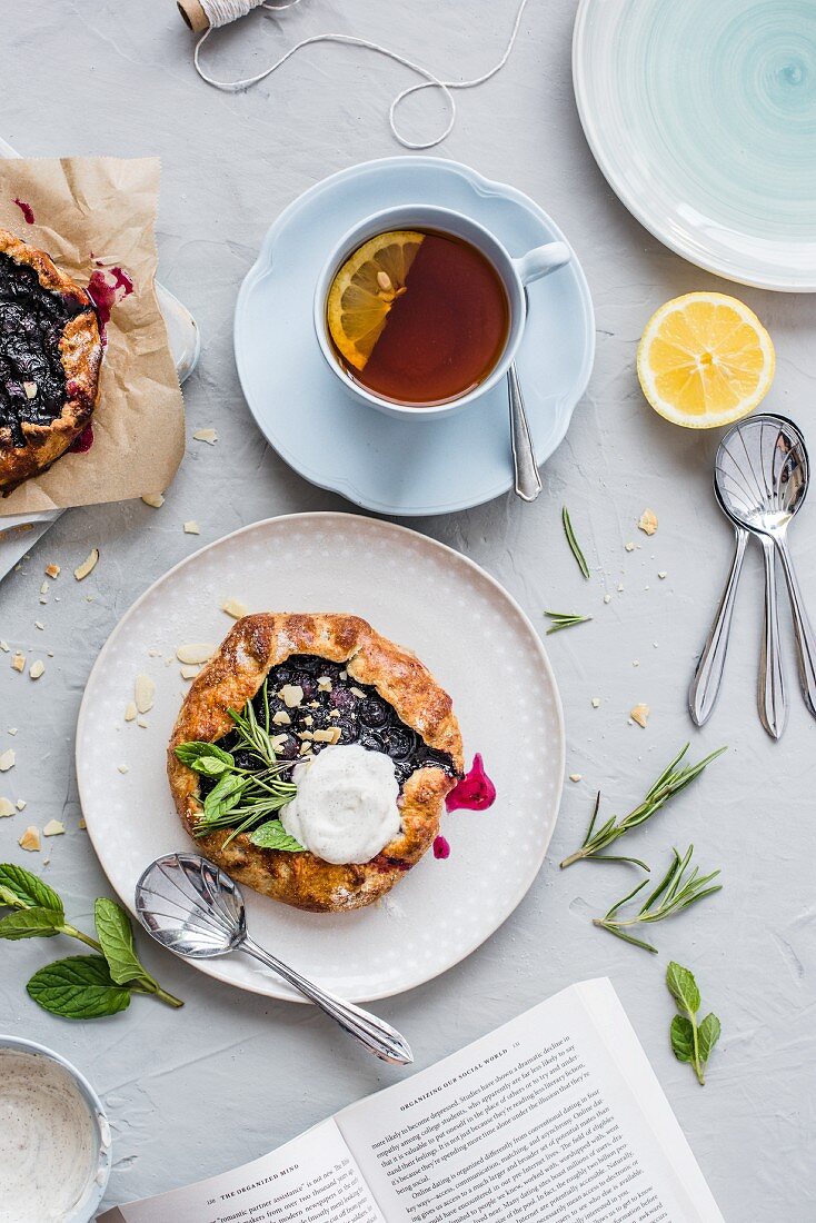 Blueberry galettes with almonds, herbs and vanilla cream served with a cup of tea