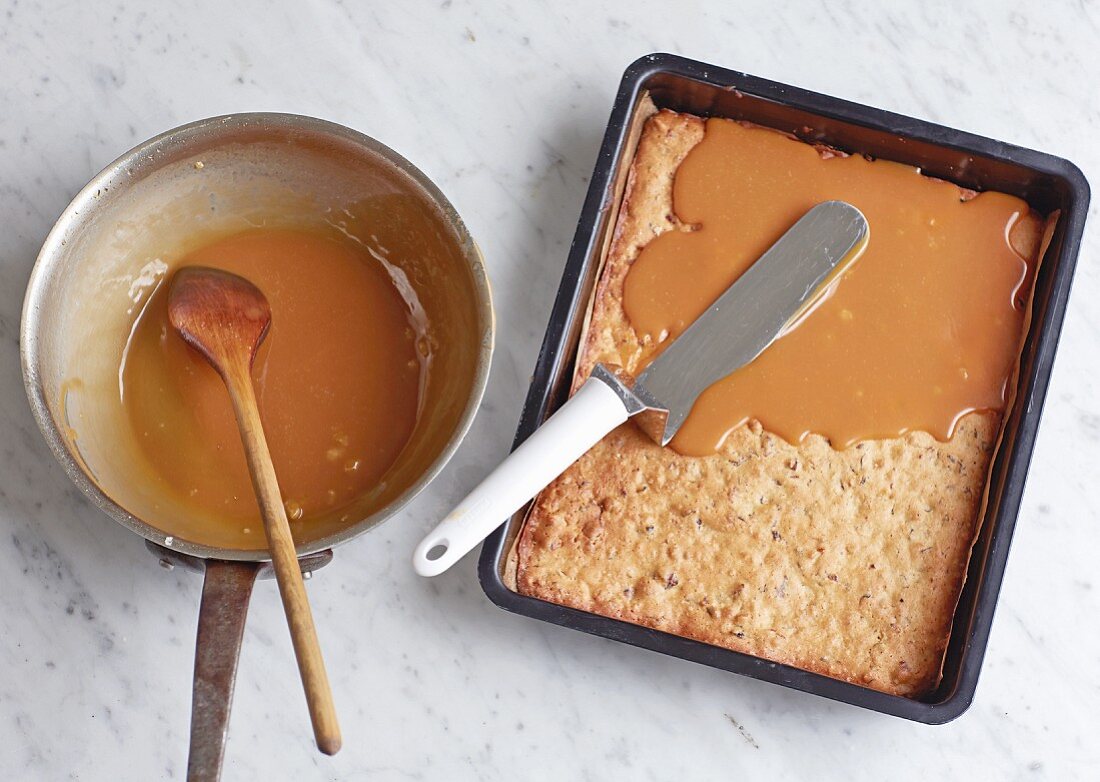 Spreading caramel onto a biscuit base