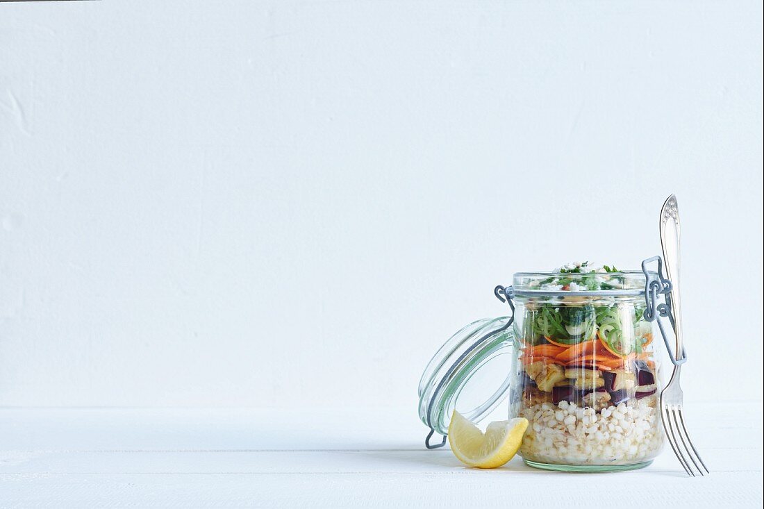 Barley salad with aubergine and feta in a glass jar