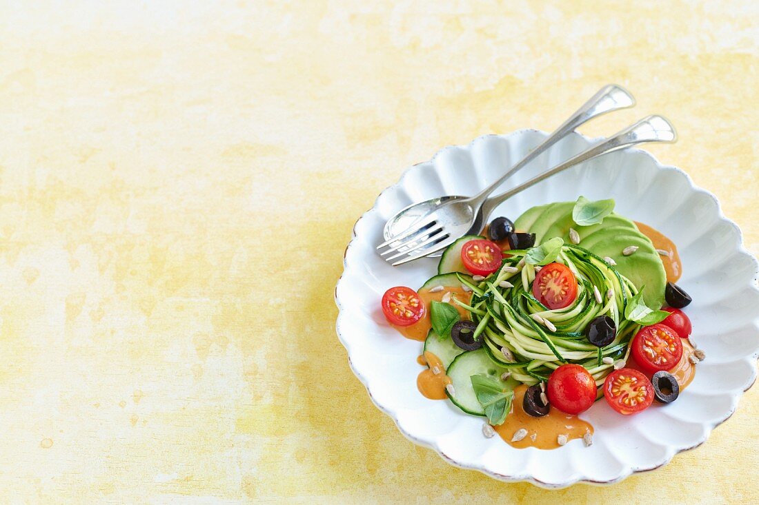 Vegane Zucchinipasta mit Avocado, Oliven und Tomatensauce