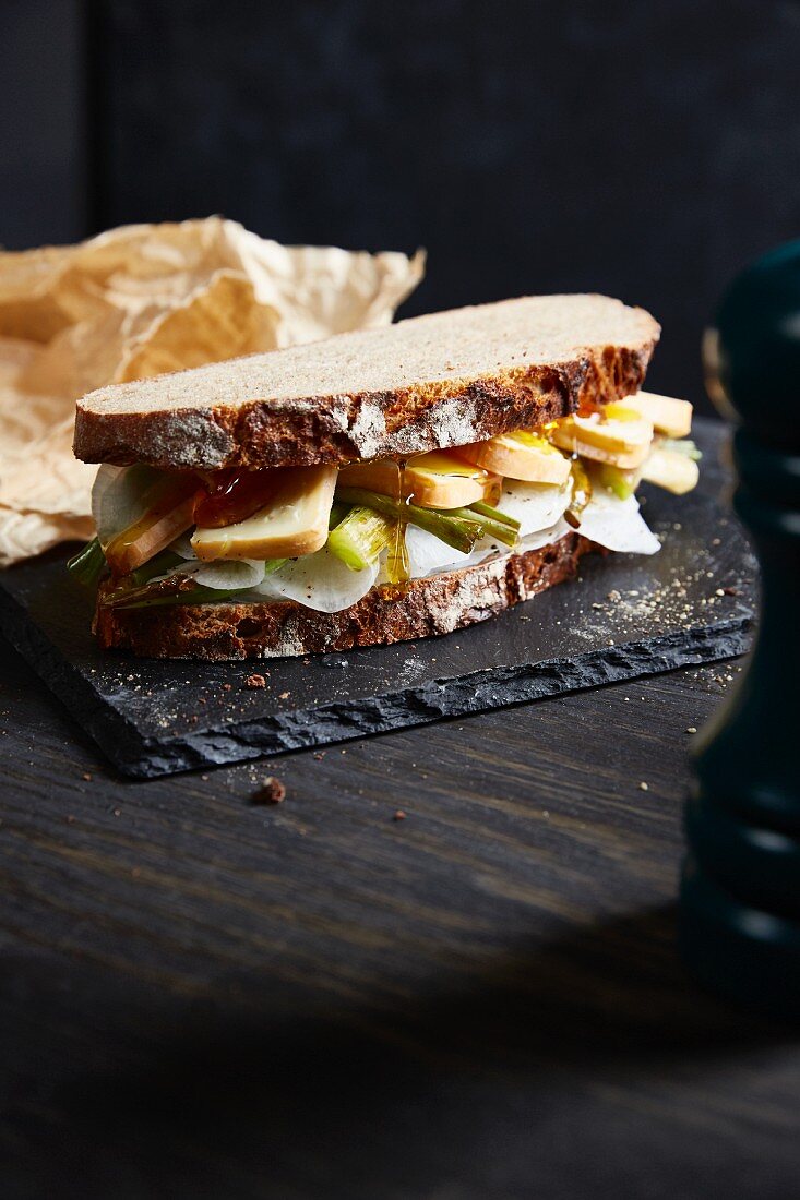 Bauernbrot-Sandwich mit weißem Rettich, Rotschmierkäse und Honig