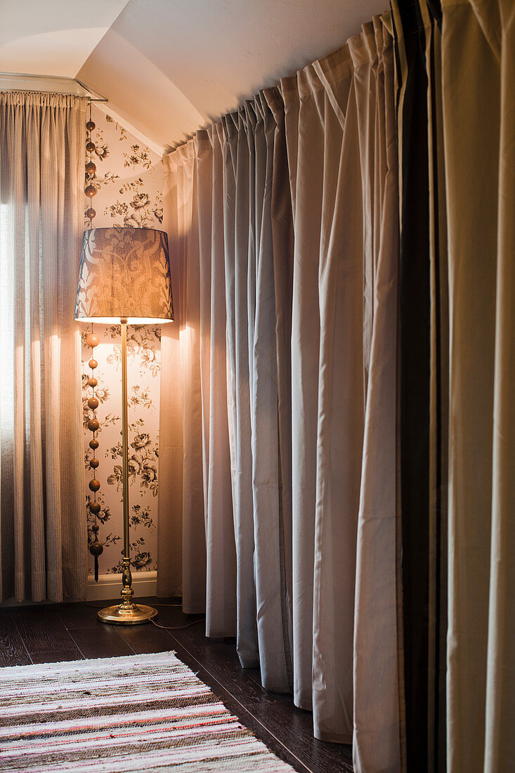 Bodenlanger Vorhang vor Umkleide und Stehlampe im Schlafzimmer