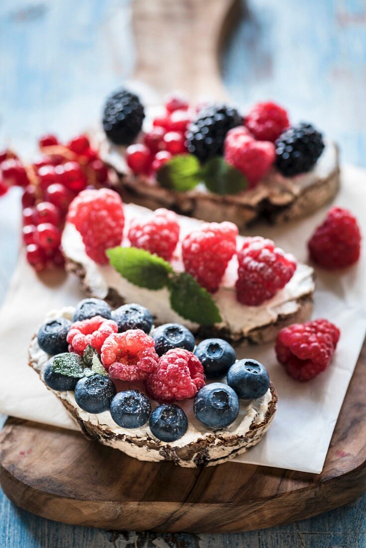 Berry and cream cheese bruschetta on a wooden board