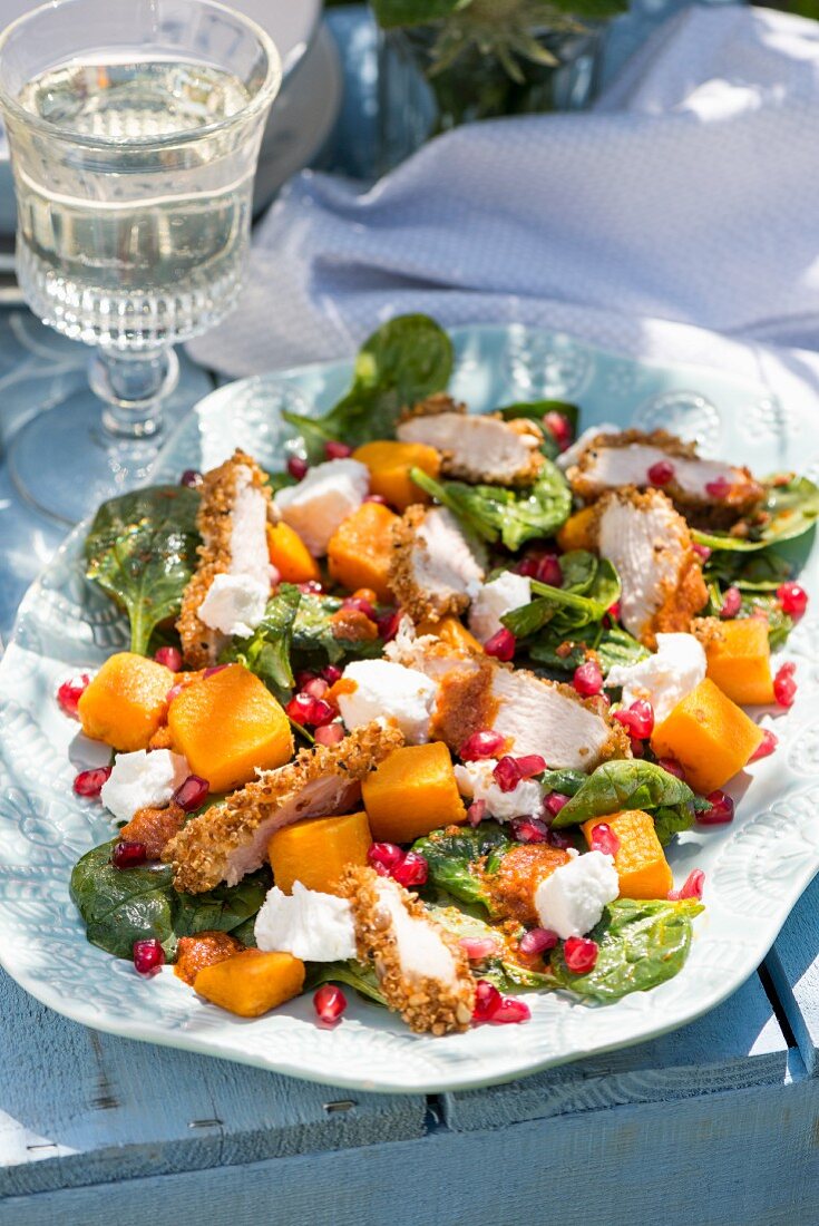 Chicken salad with pumpkin, goat's cheese, spinach and pomegranate dressing