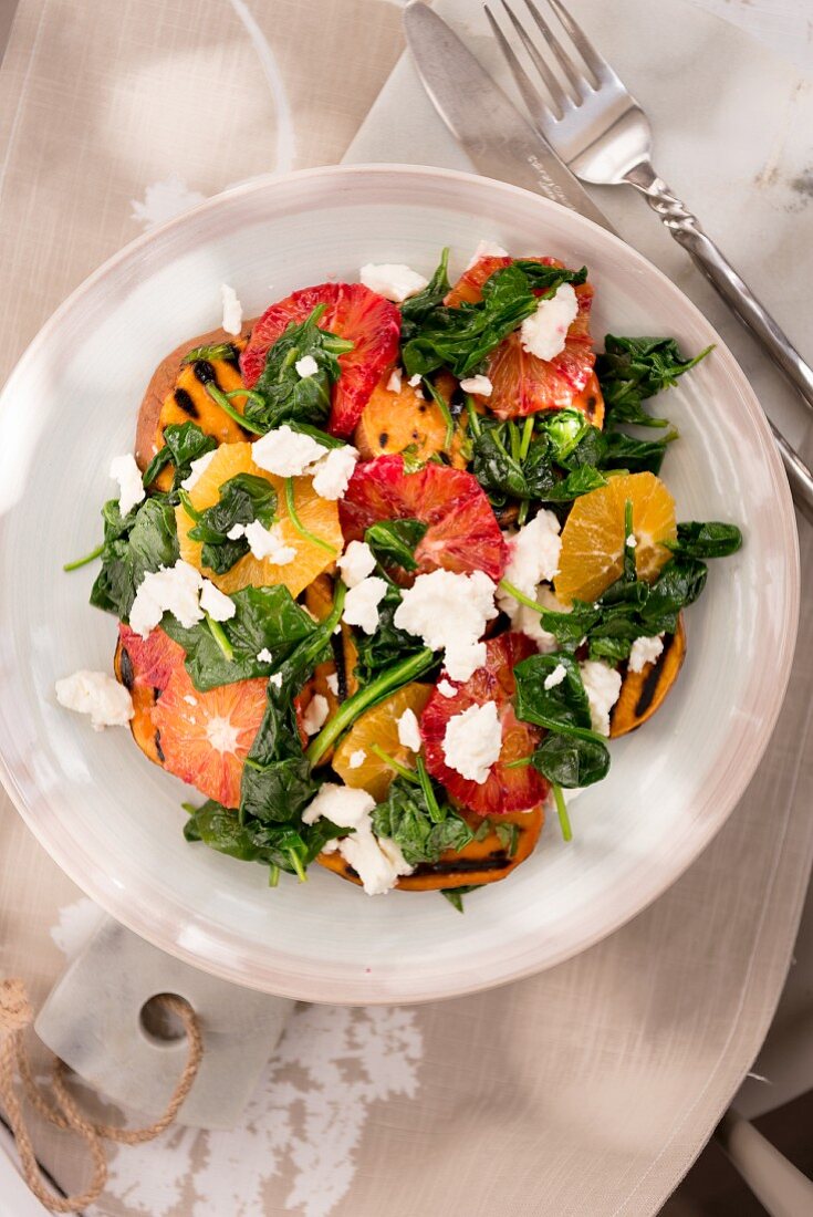 Warm spinach salad with orange, grilled sweet potato and feta