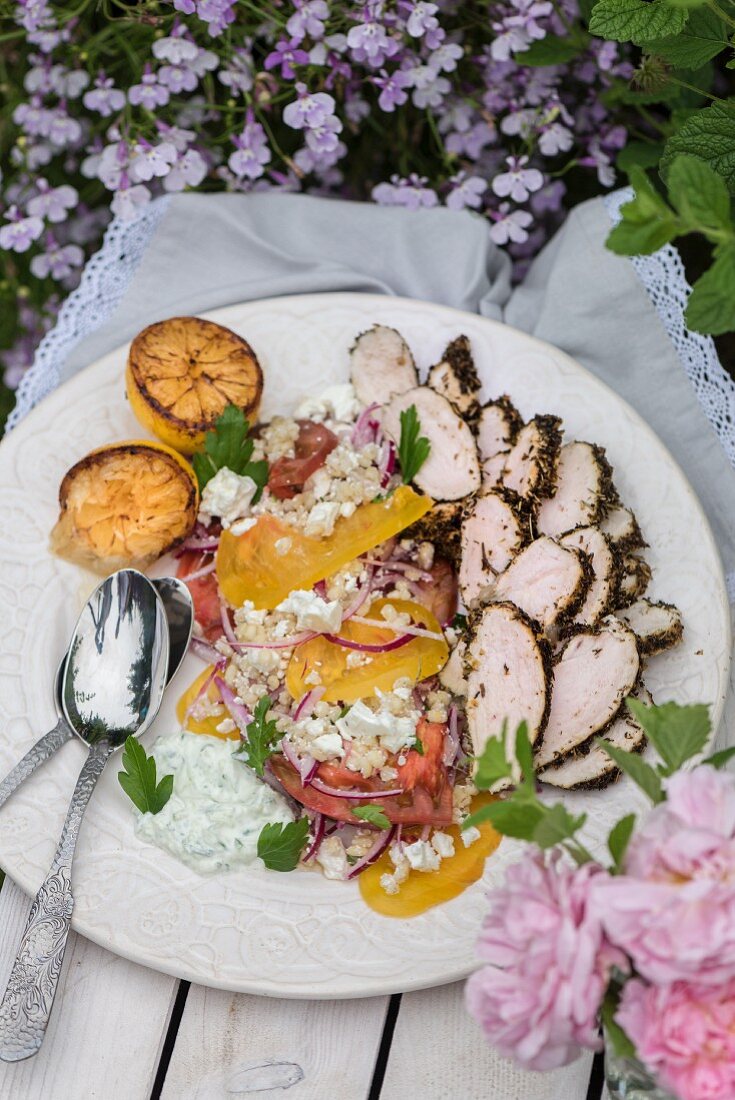 Chicken breast with a herb crust served with tomatoes, yellow pepper and feta with yoghurt cream dip