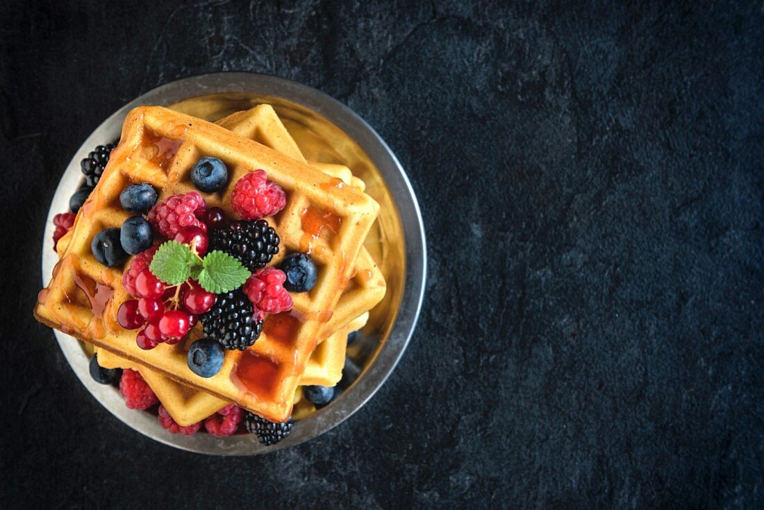 Belgische Waffeln mit frischen Beeren auf Teller (Aufsicht)