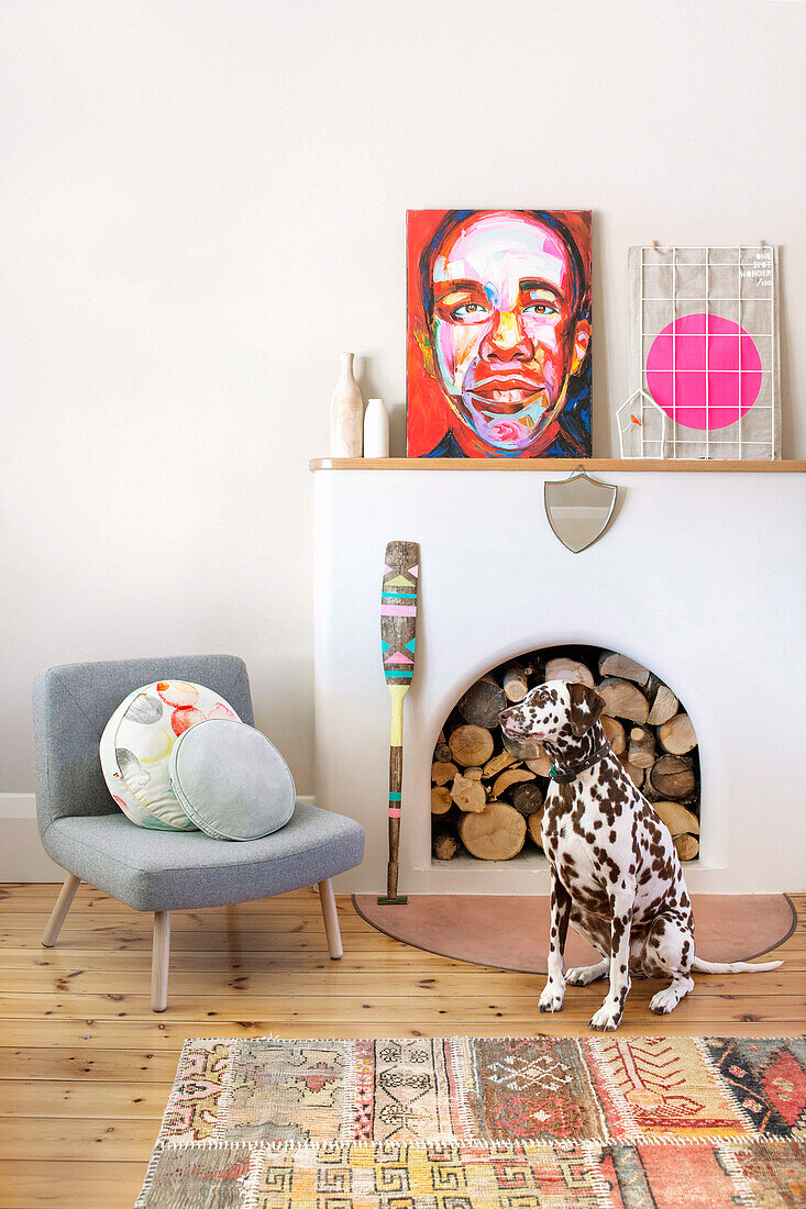 Reading corner with armchair, art and Dalmatian next to the fireplace