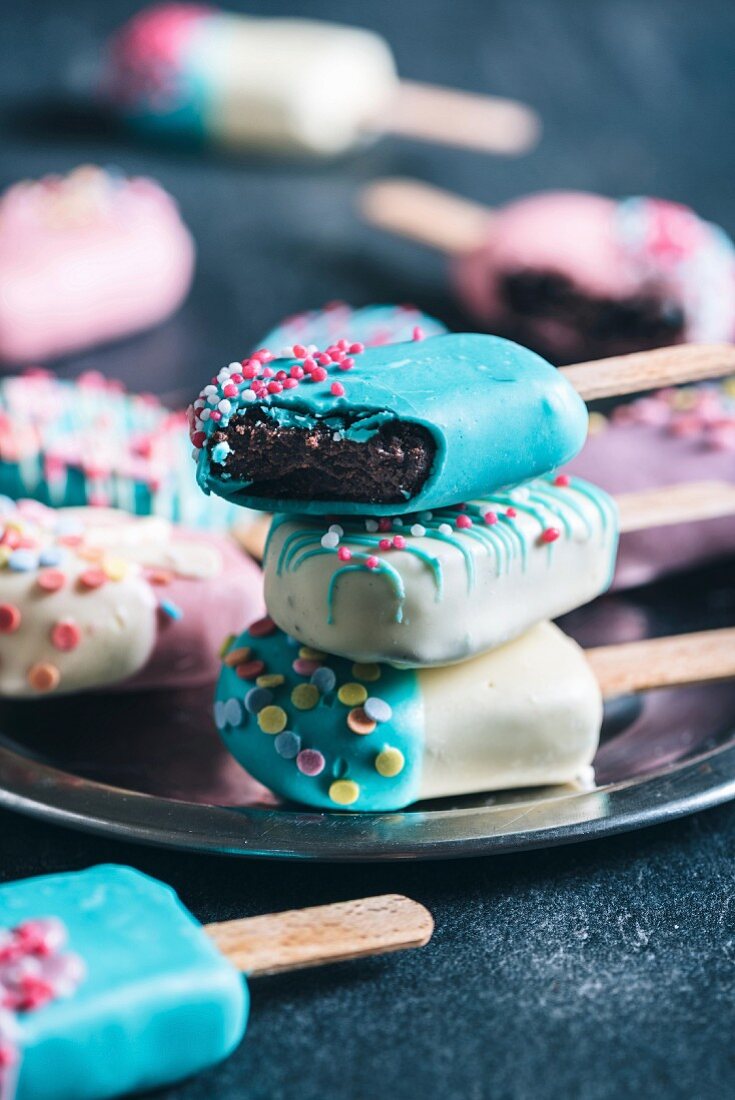 Cake pops in the shape of ice lollies with brightly coloured icing (close-up)