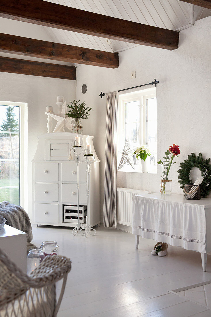 White living room decorated for Christmas with exposed roof structure