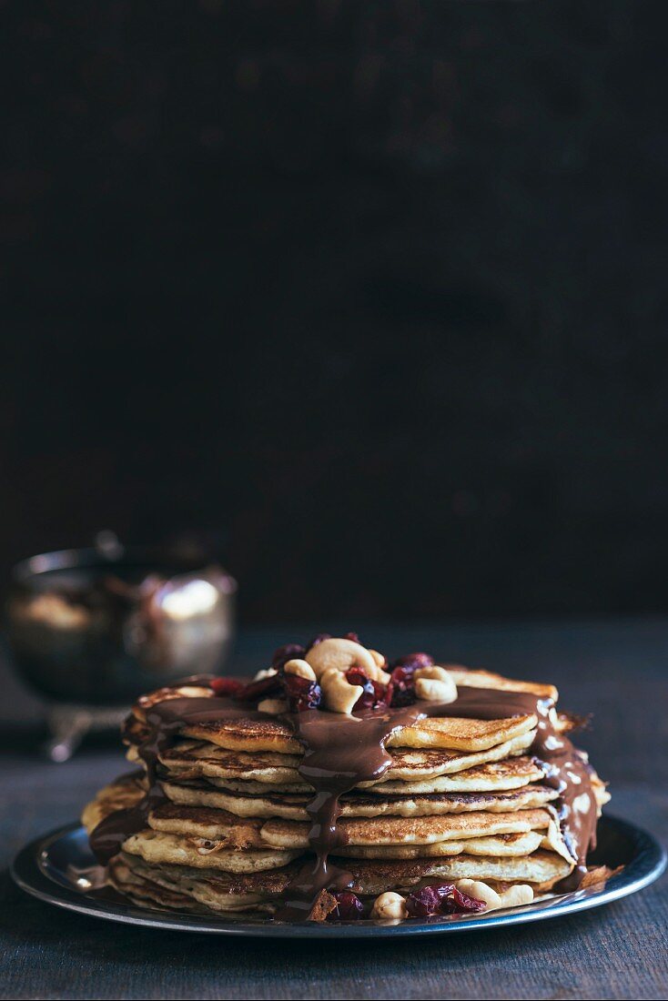 Gestapelte Pancakes mit Schokoladensauce und Nüssen