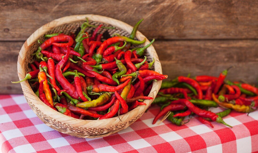 Fresh chillies in a wicker basket at a market